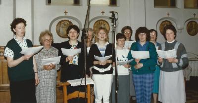 De dames van het Nazarethse parochiekoor treden op in de kinderkribbe
