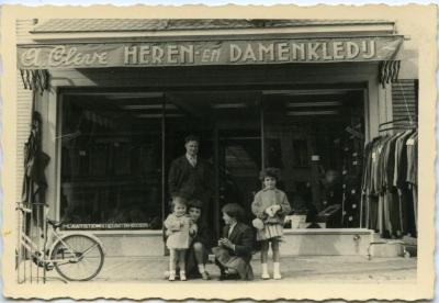 Familie poseert voor stoffen- en kleerwinkel A. Cleve 